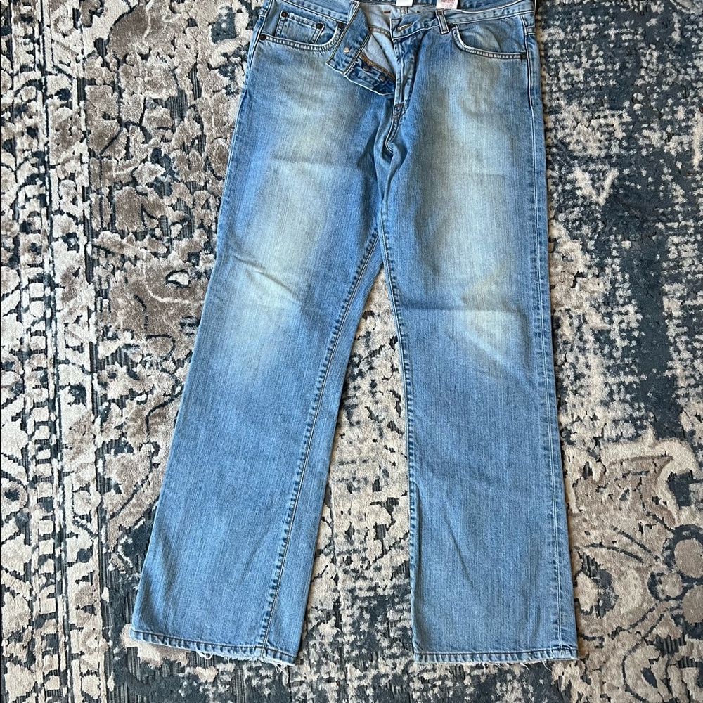 Button fly Lucky brand slightly distressed blue jeans.